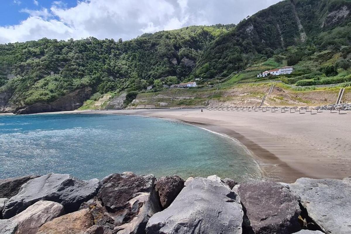 Una playa con rocas y el océano y las montañas.