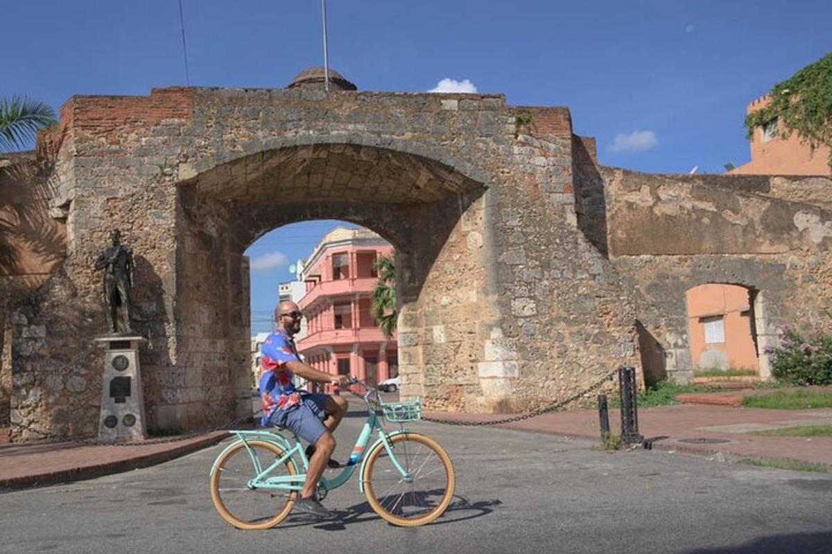 a man riding a bike in front of an arch