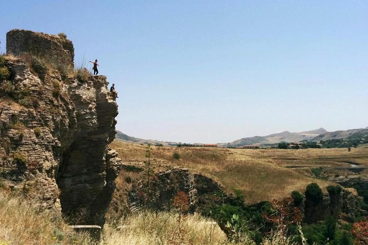 una persona in piedi in cima a una scogliera
