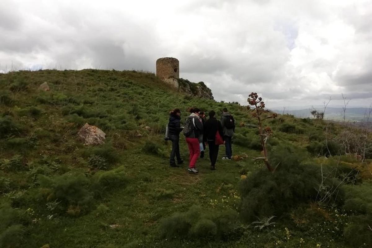 un gruppo di persone che cammina su una collina con una torre