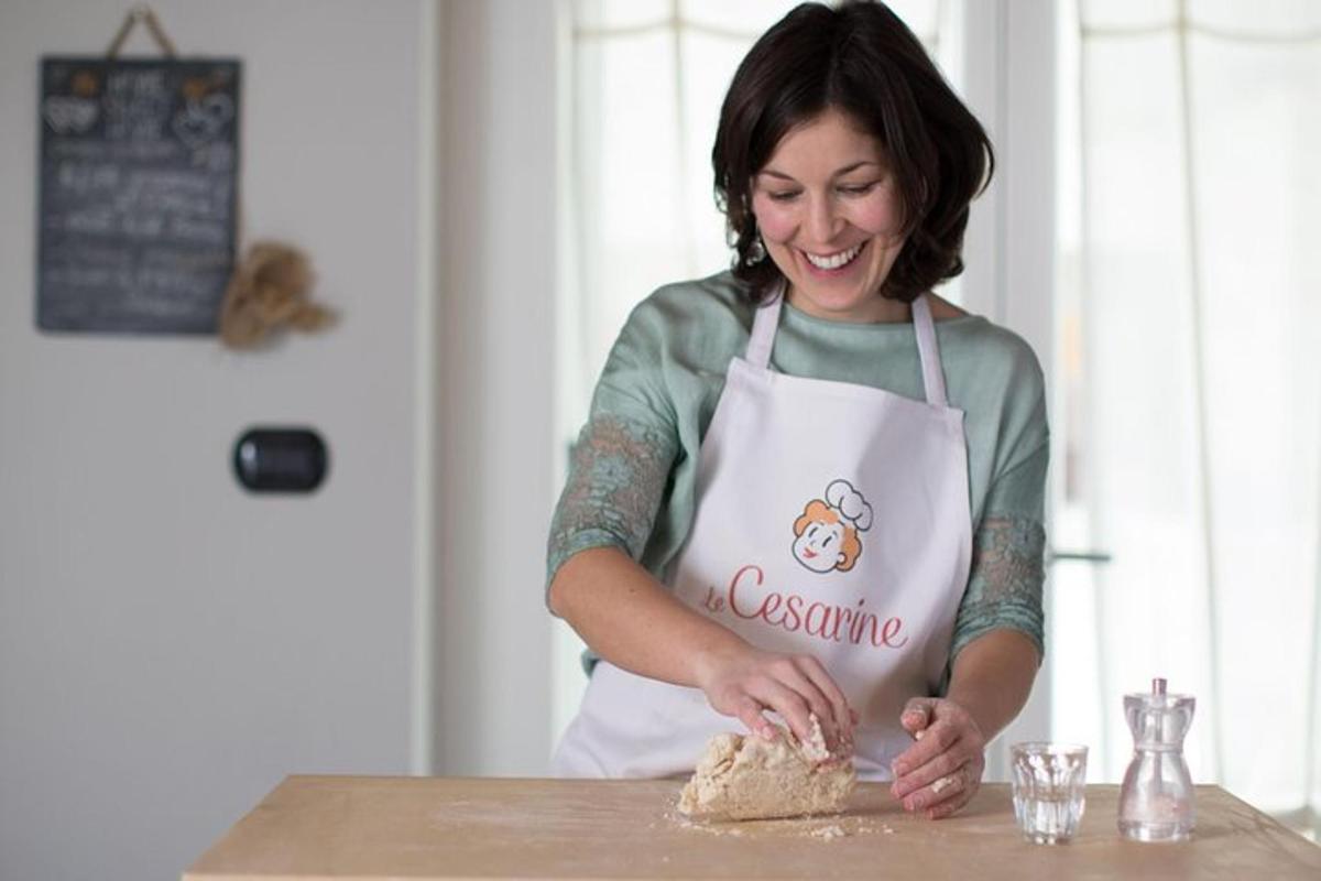 a woman in an apron standing at a table making food