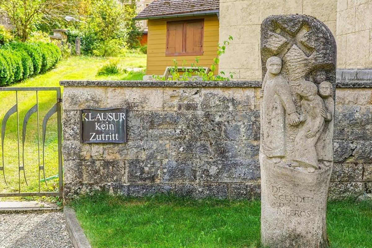 una estàtua d'una dona sostenint un nen al costat d'una tanca