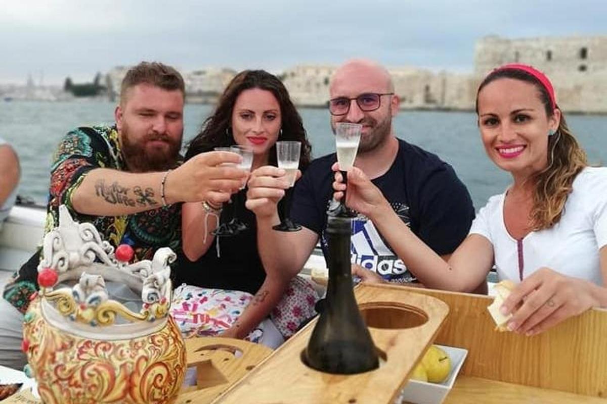 skupina lidí sedících u stolu s vinnými sklenicemi