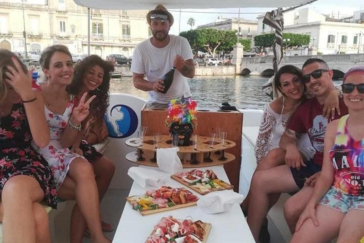 skupina lidí sedících na lodi s jídlem