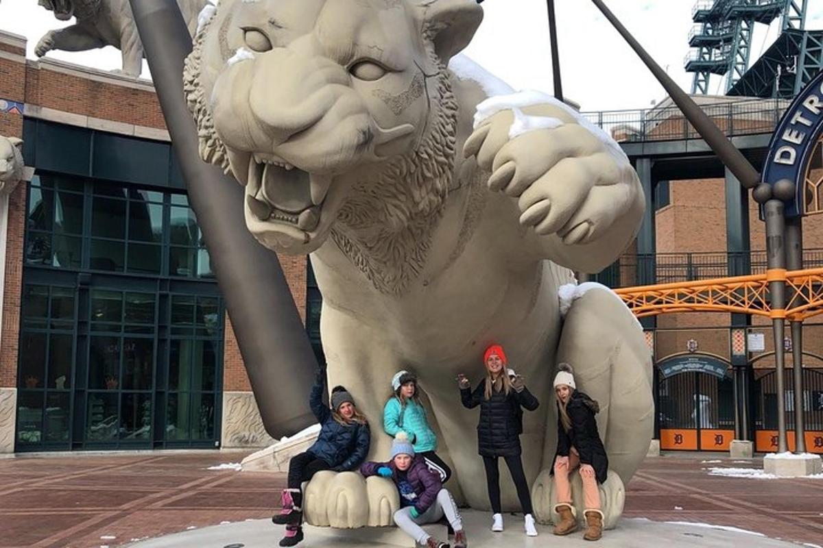 a group of people posing in front of a statue of a lion