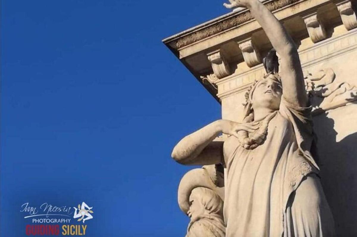 una estatua de una mujer en el costado de un edificio