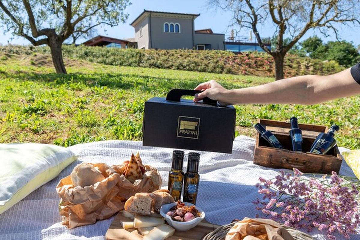 Una mesa de picnic con una caja de vino y comida.