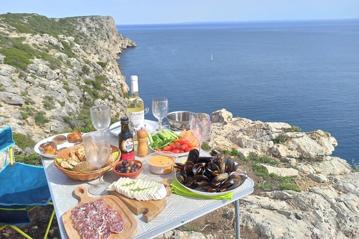 a table with food and wine on top of a cliff
