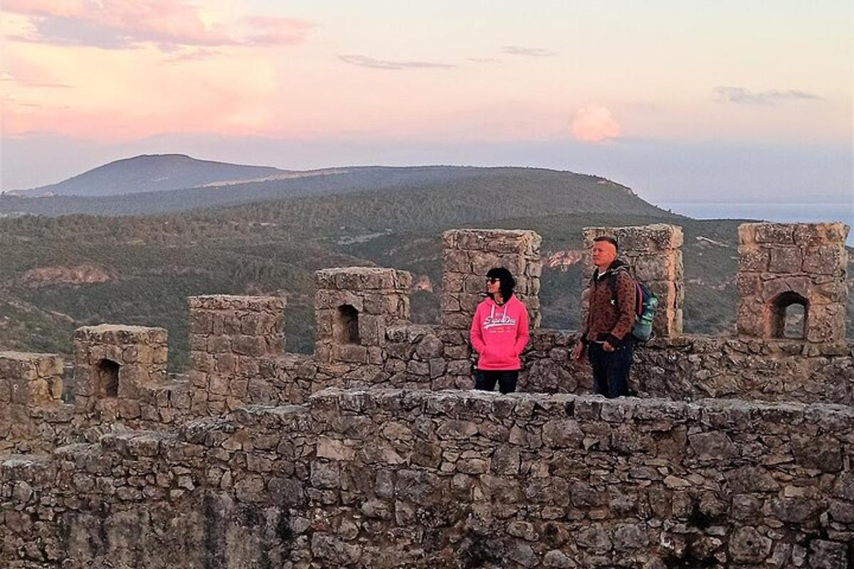 a man and a woman standing on top of a stone wall