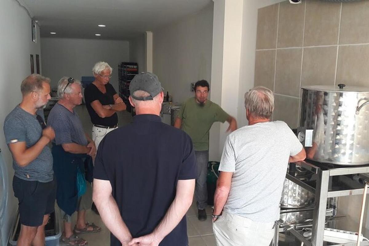 skupina moških, ki stojijo skupaj v kuhinji