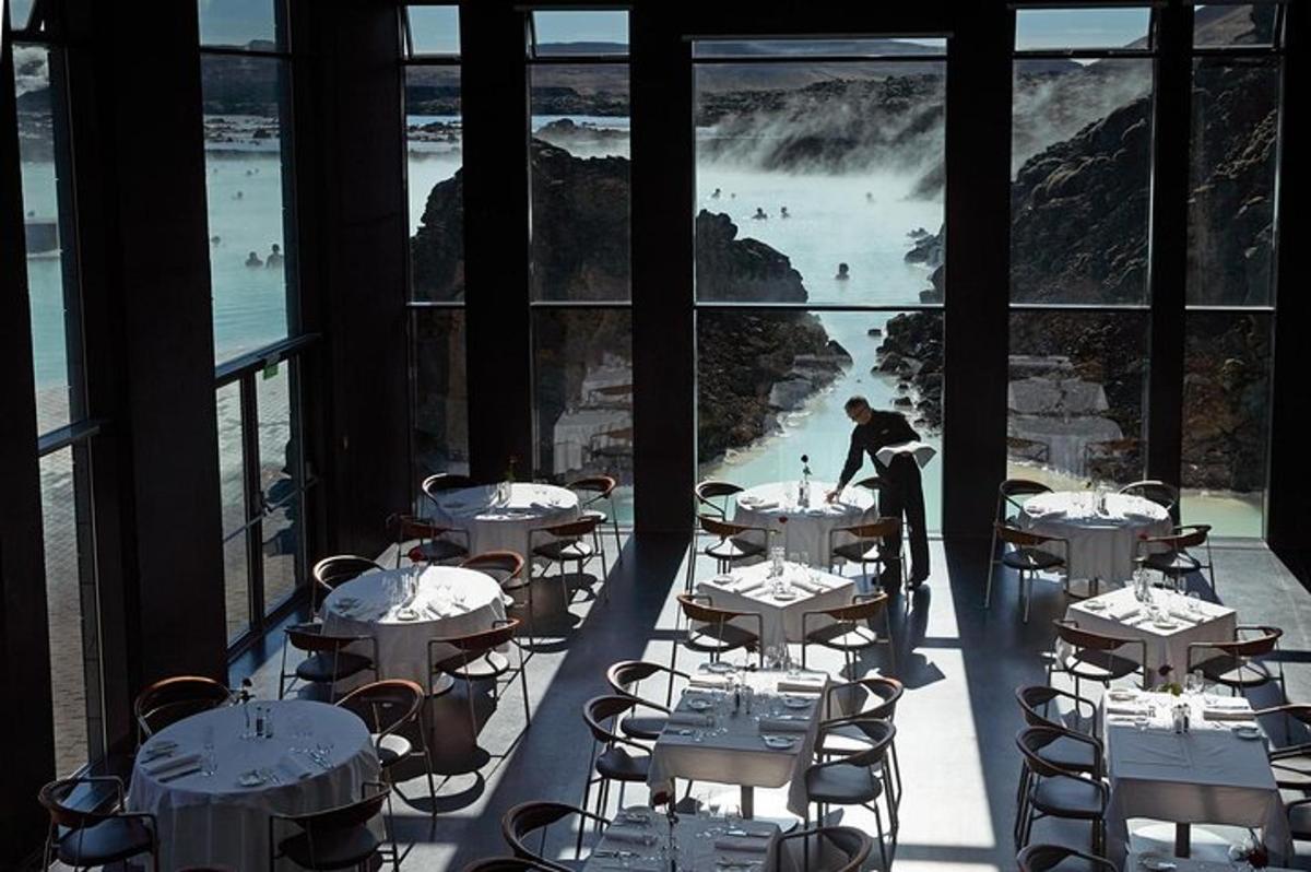 a restaurant with tables and chairs with a view of the ocean