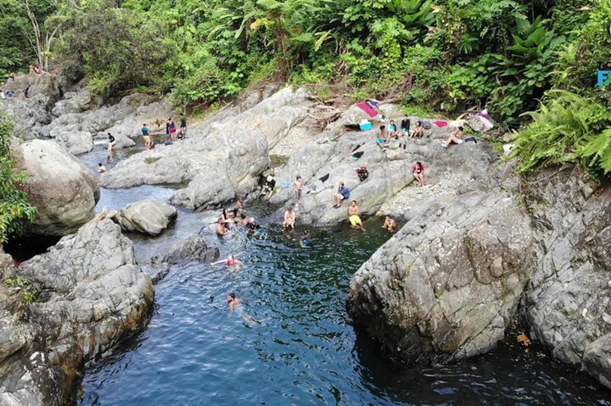 a group of people swimming in a river with rocks