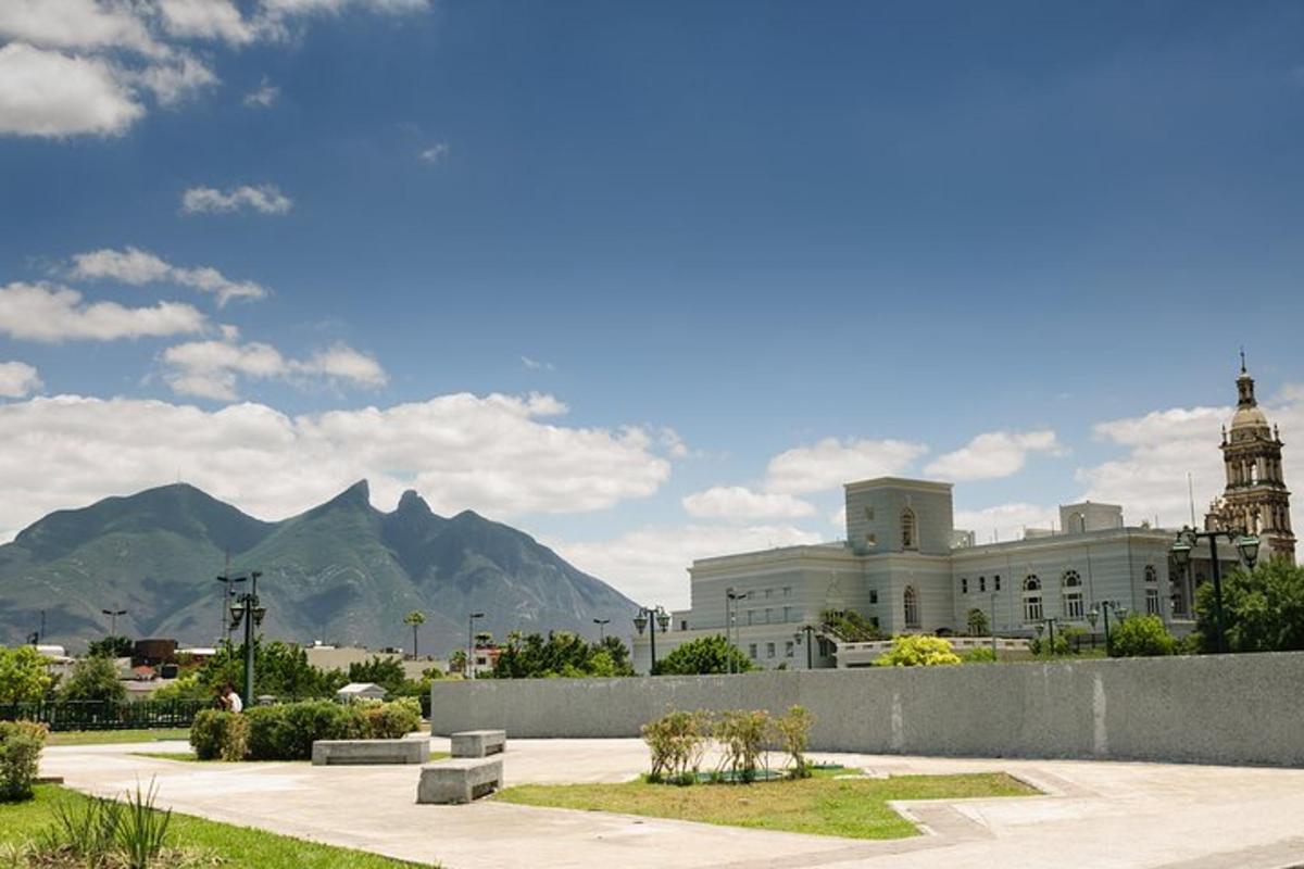 a large white building with mountains in the background