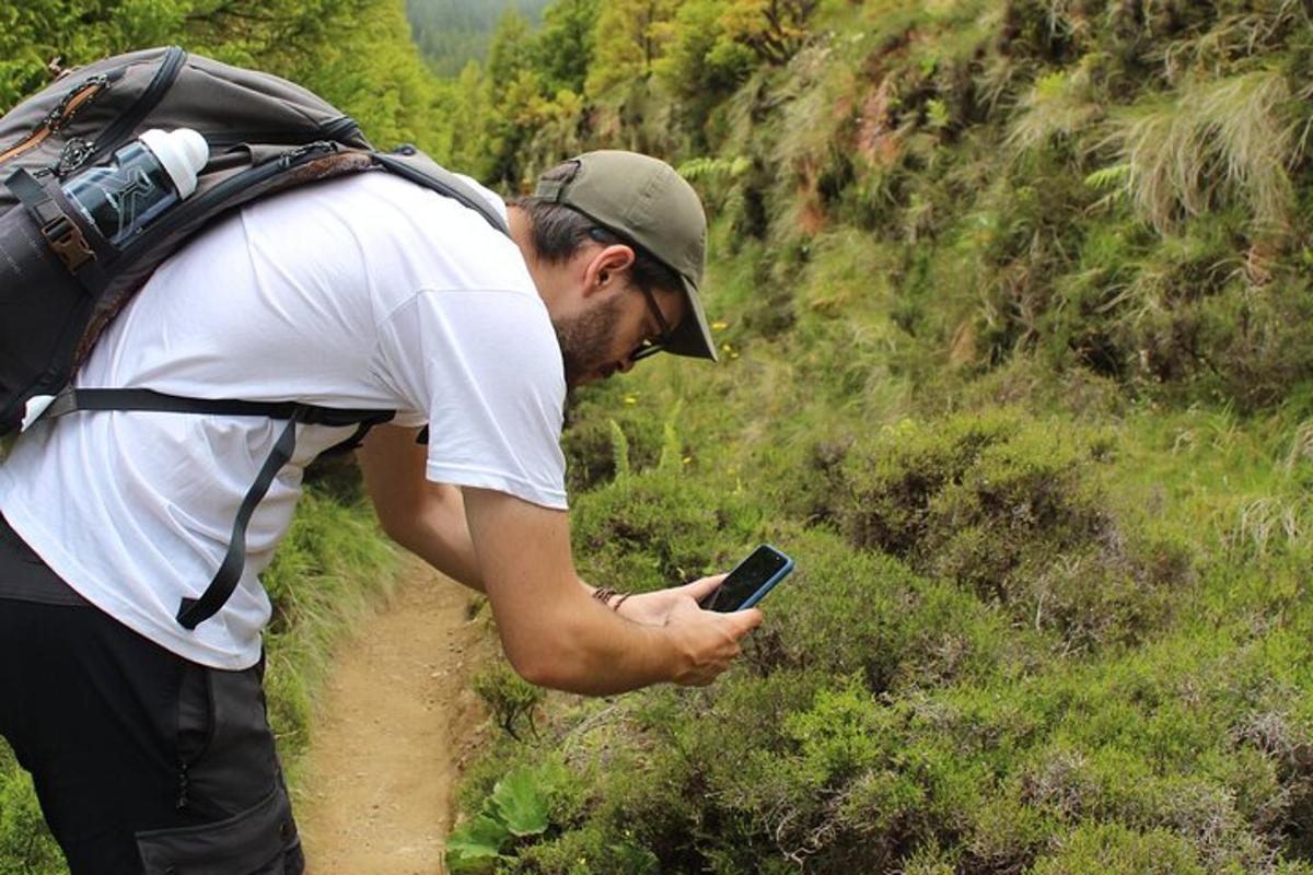 un uomo in piedi su un sentiero che guarda un cellulare