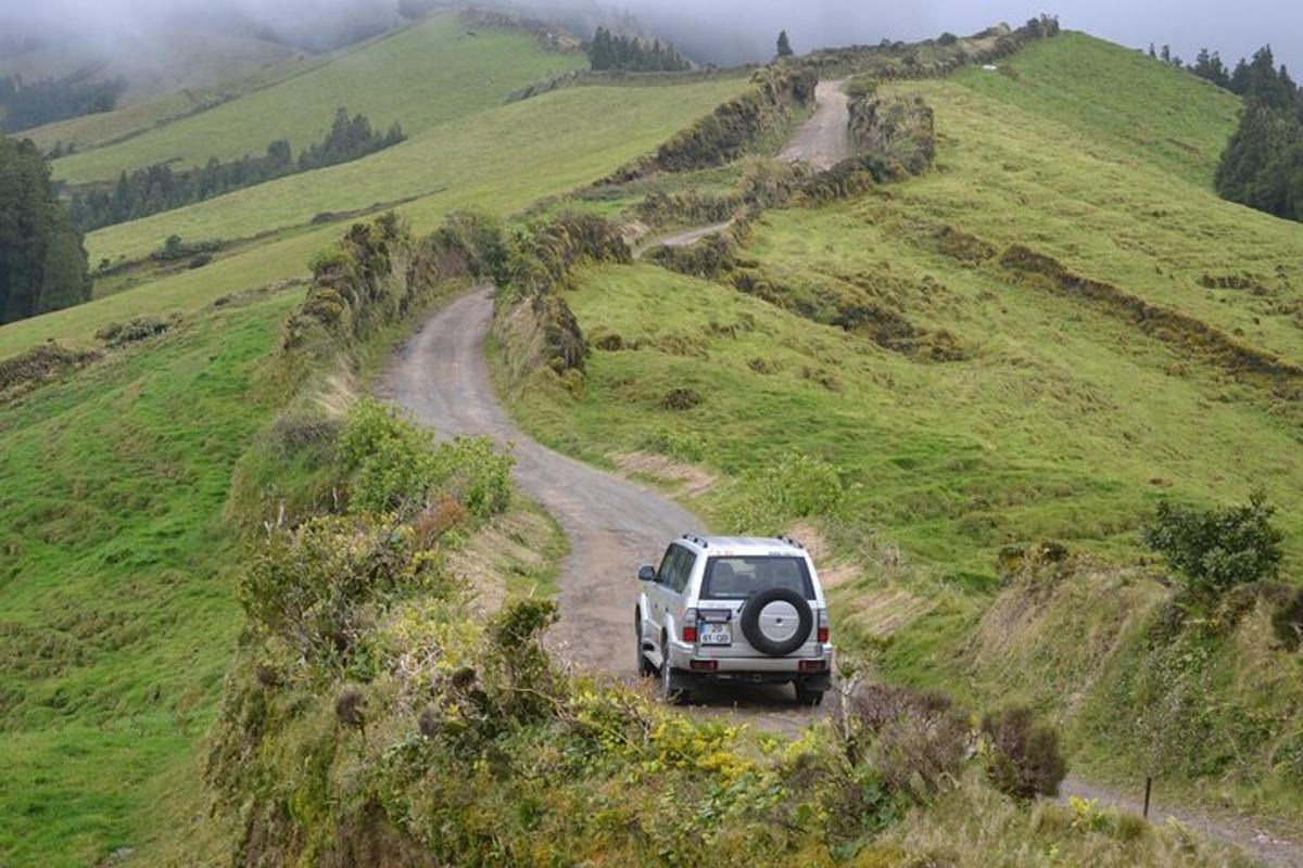 un cotxe que baixa per un camí de terra en un turó