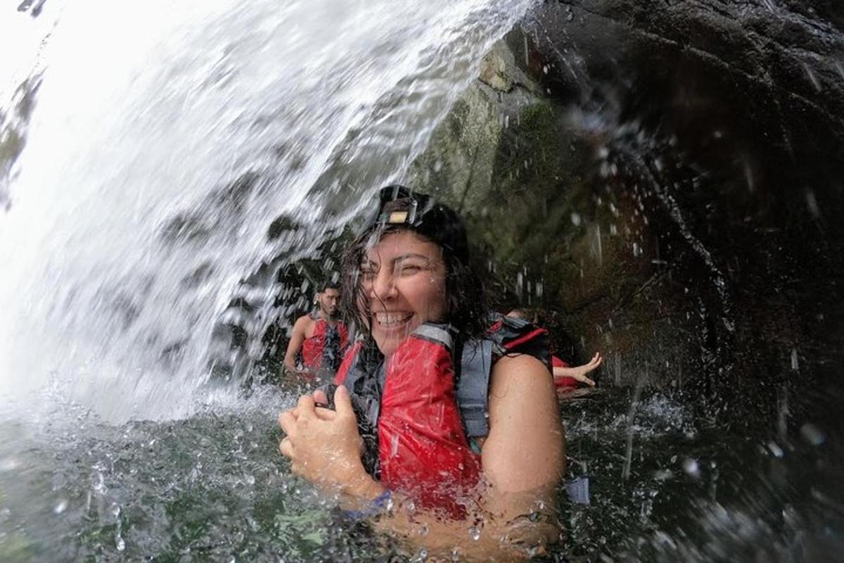 a woman is standing in front of a waterfall