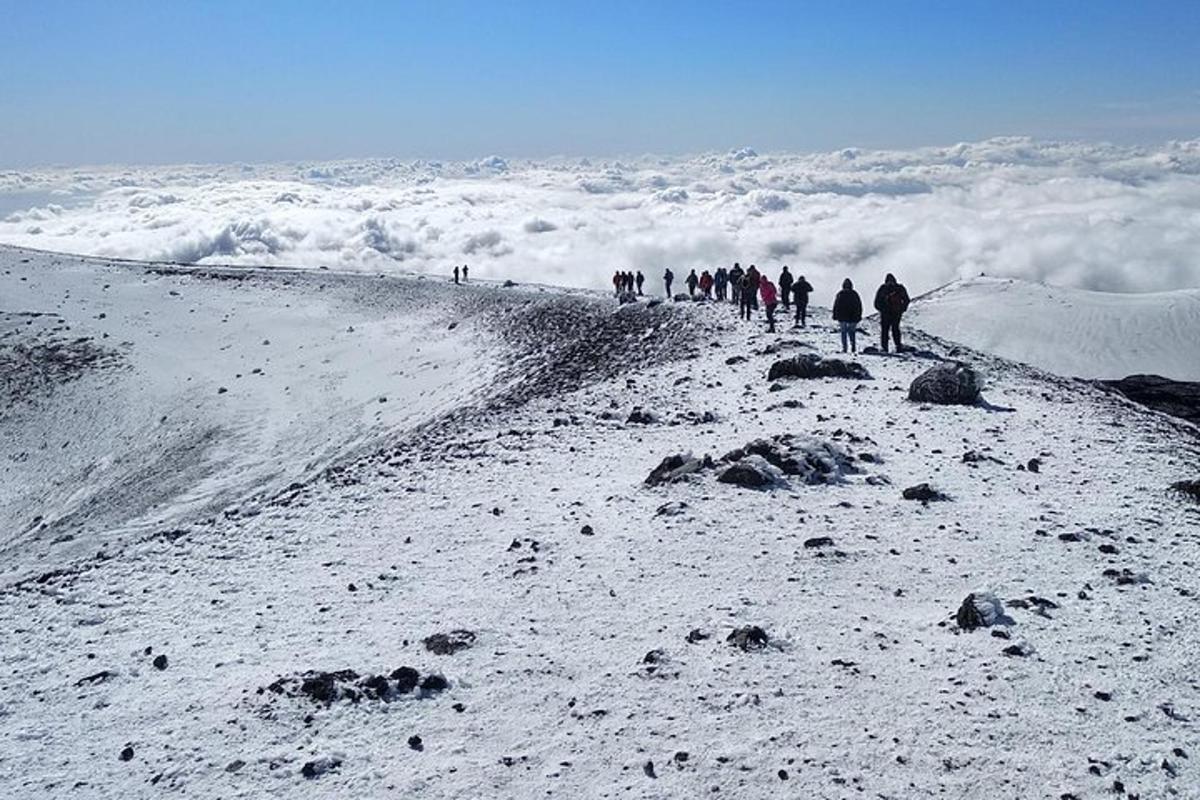um grupo de pessoas subindo uma montanha coberta de neve