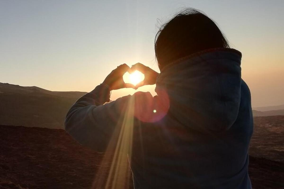 una donna che tiene il sole davanti al viso