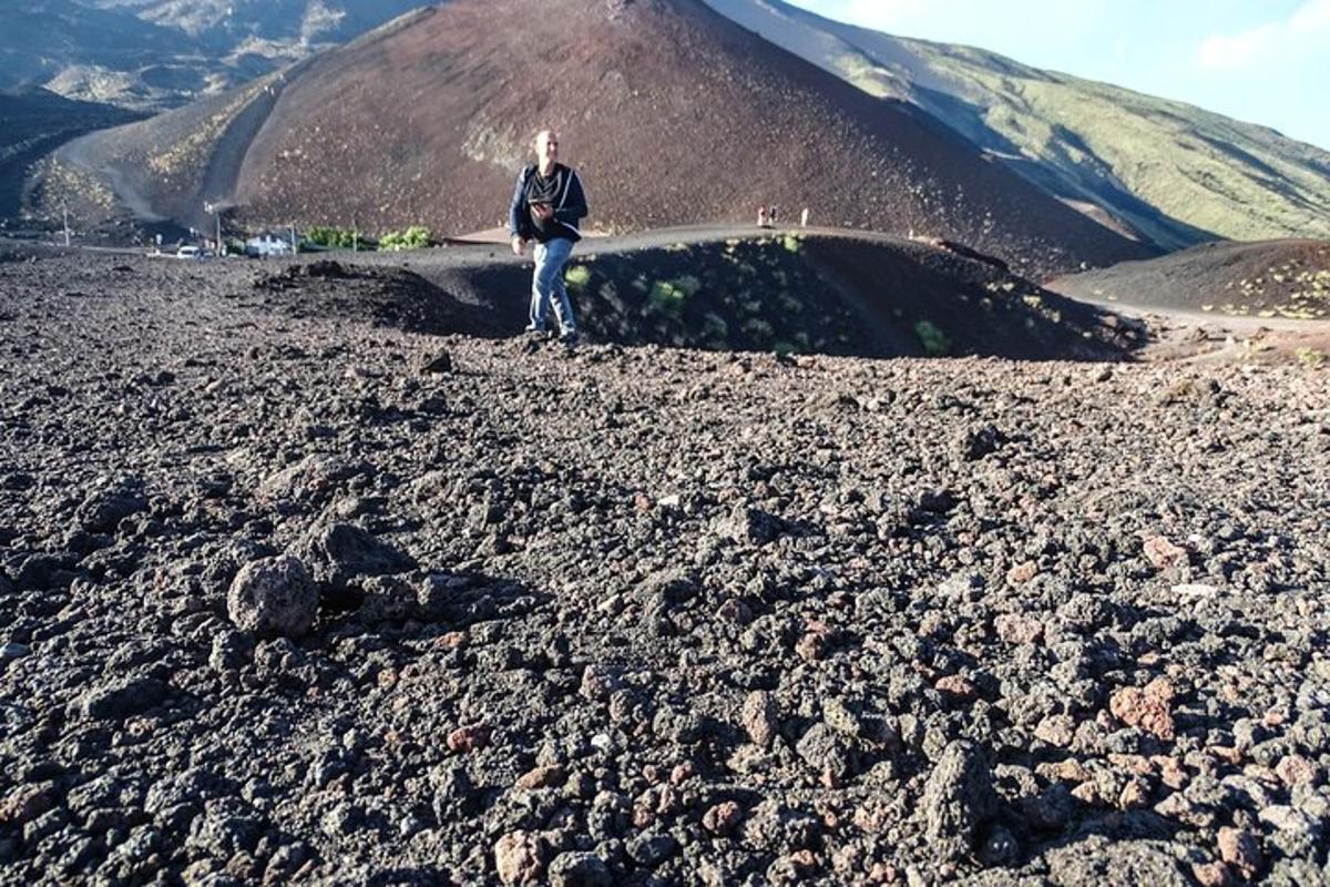 un uomo in piedi sulla cima di una montagna rocciosa