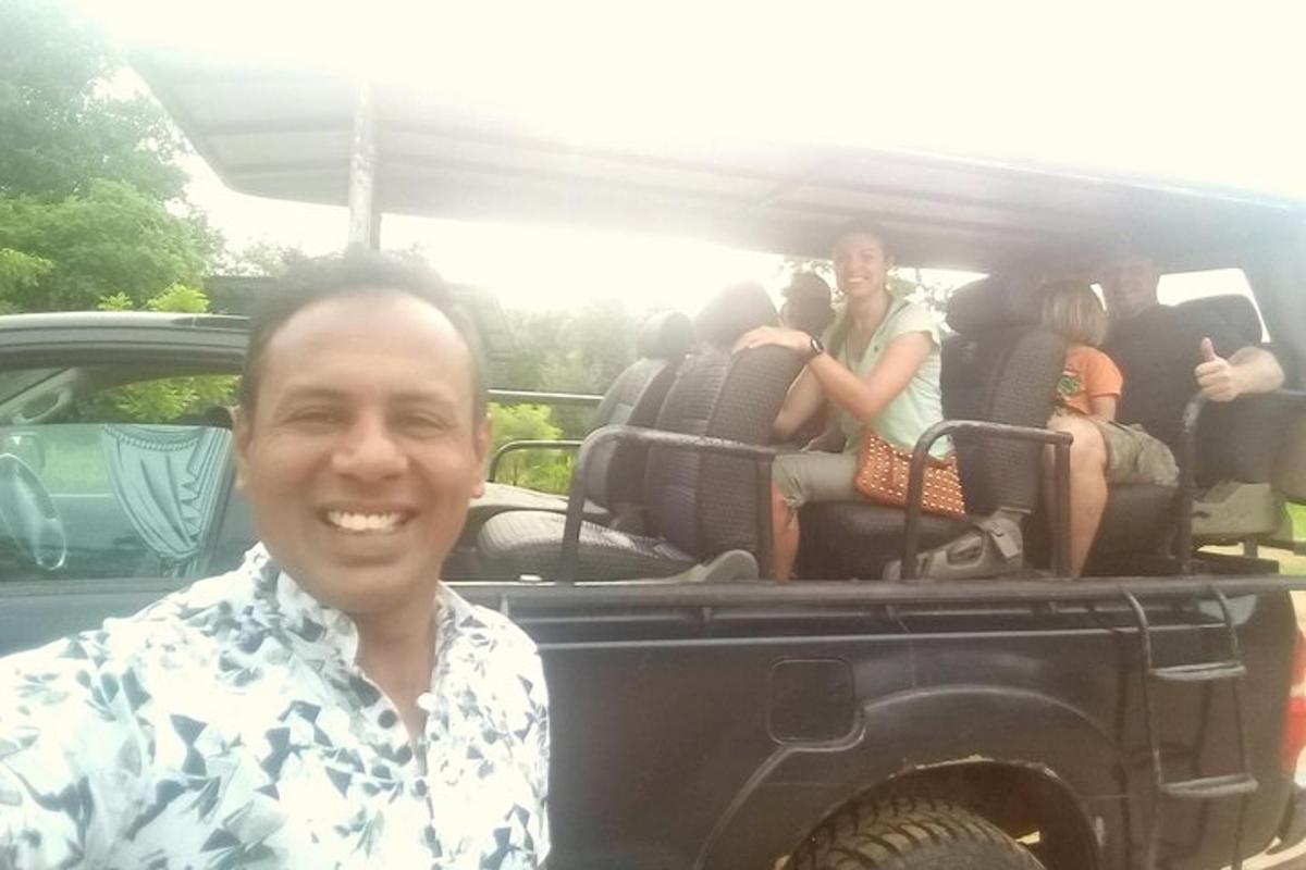 um homem parado na parte de trás de um jipe