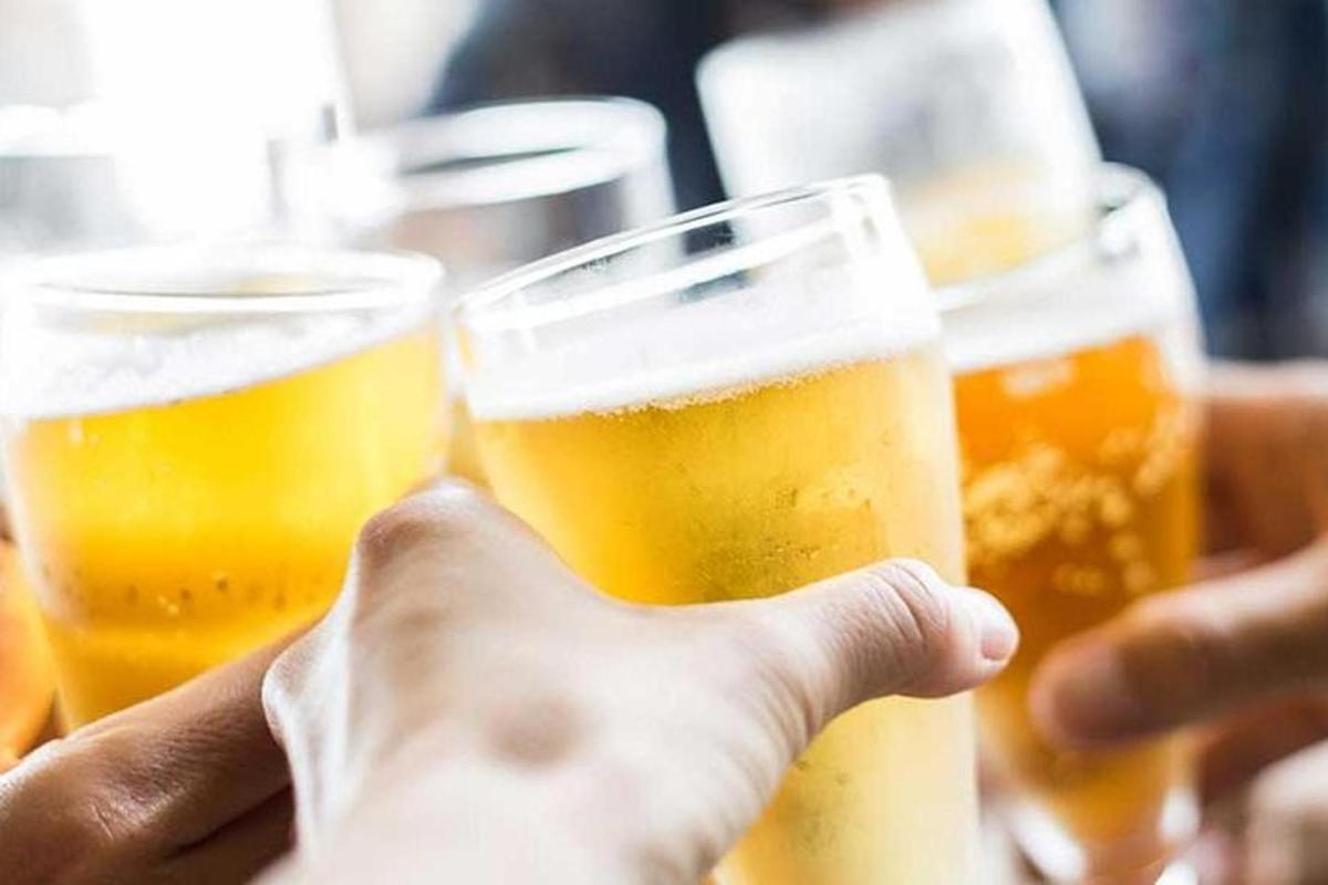 a person holding up three glasses of beer