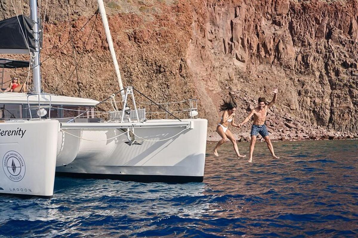 two people jumping off of a boat in the water