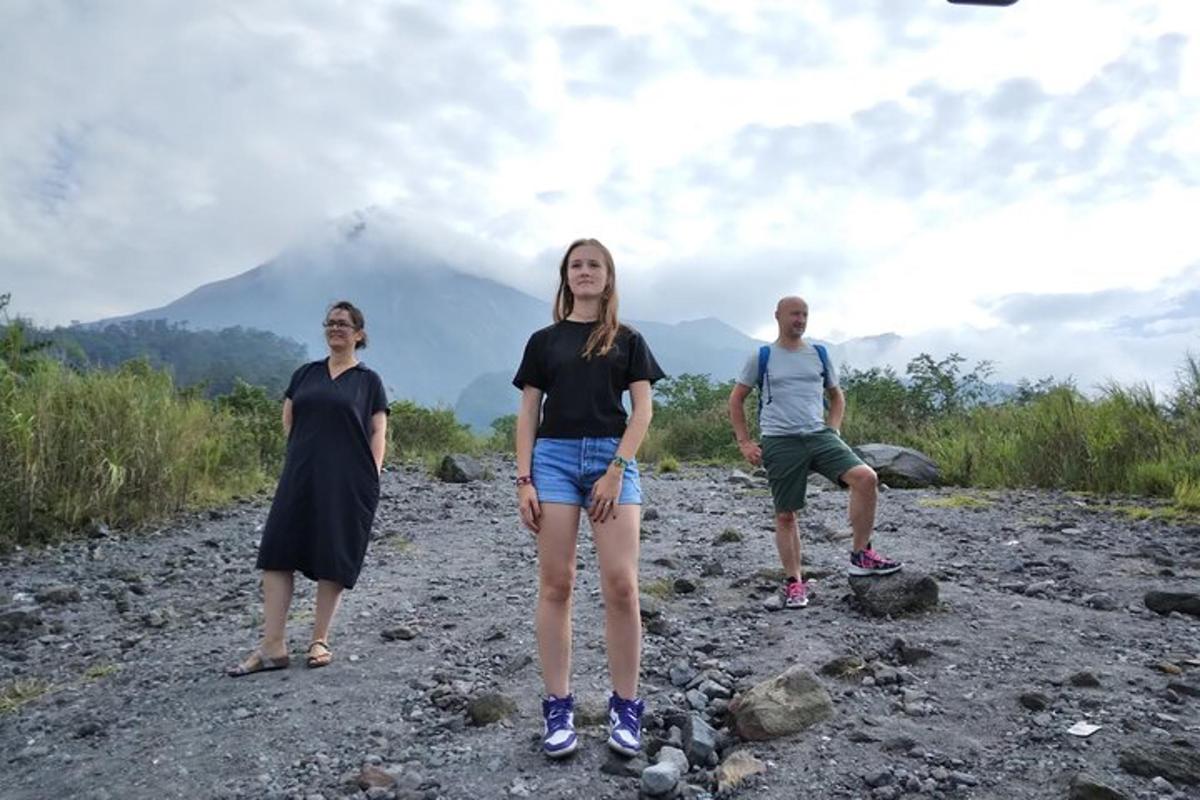 a group of three people standing on a mountain