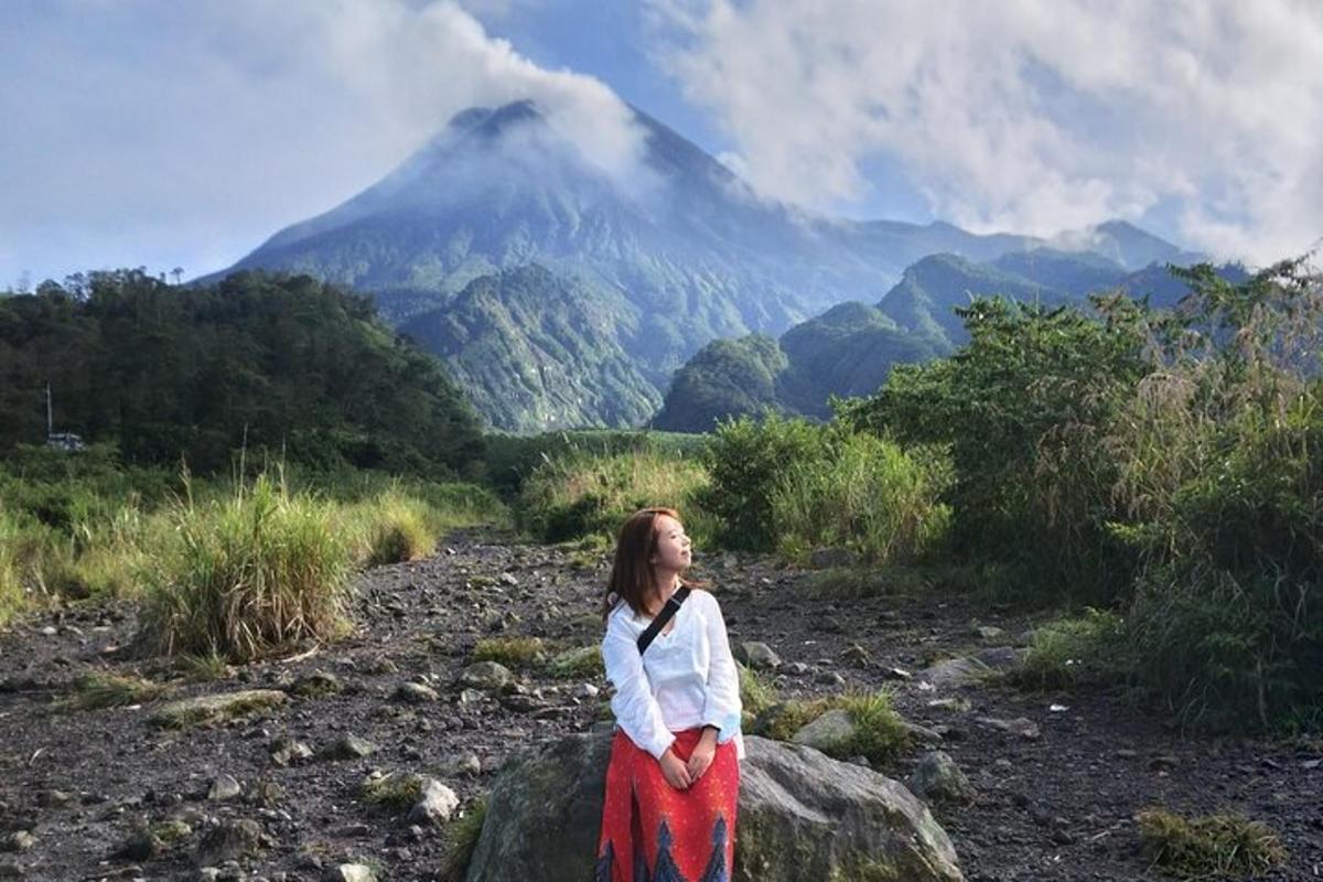 a woman standing on a rock with a mountain in the background