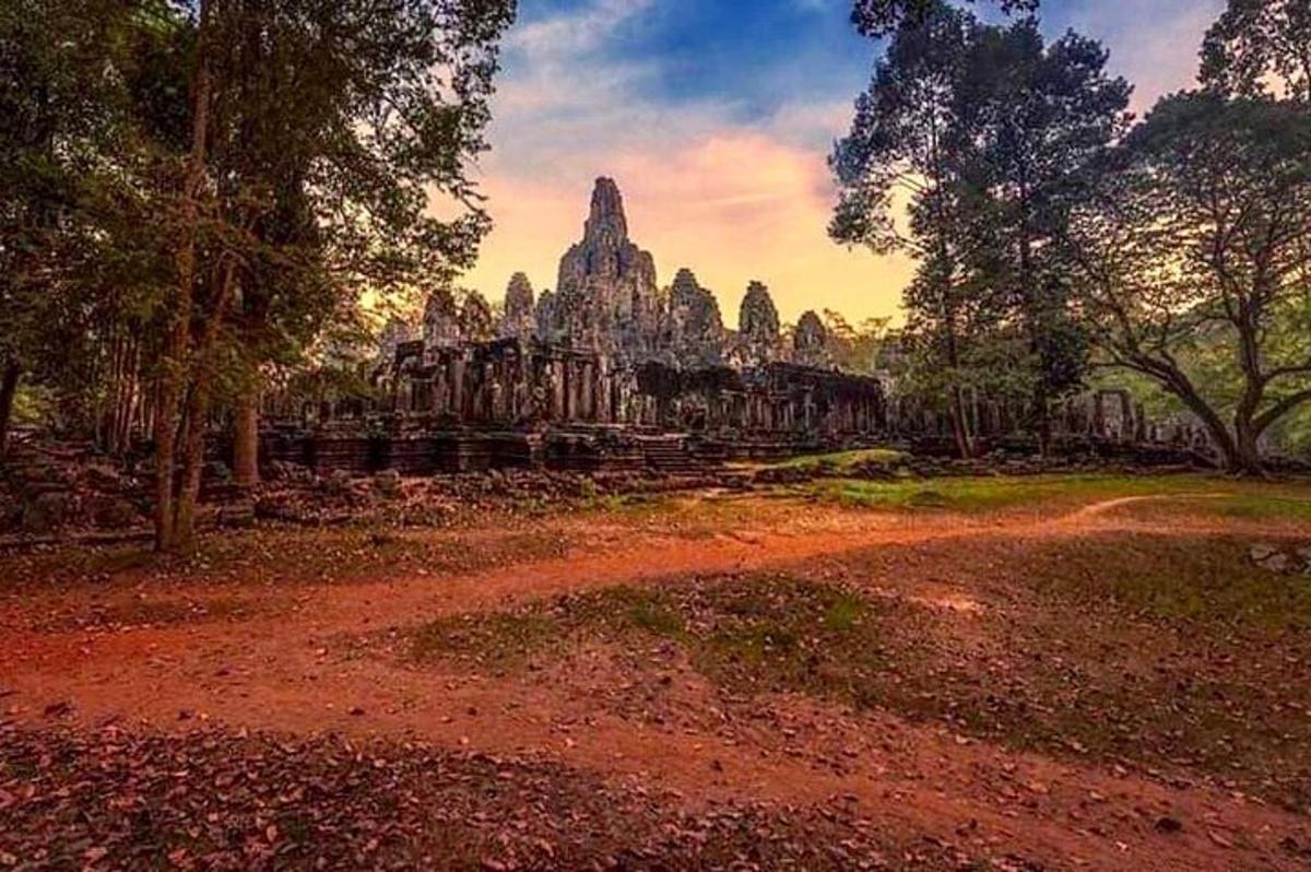 uma estrada de terra em frente a um templo de pedra