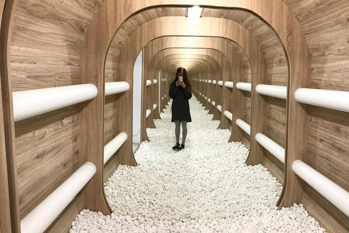 a woman walking down a tunnel with gravel