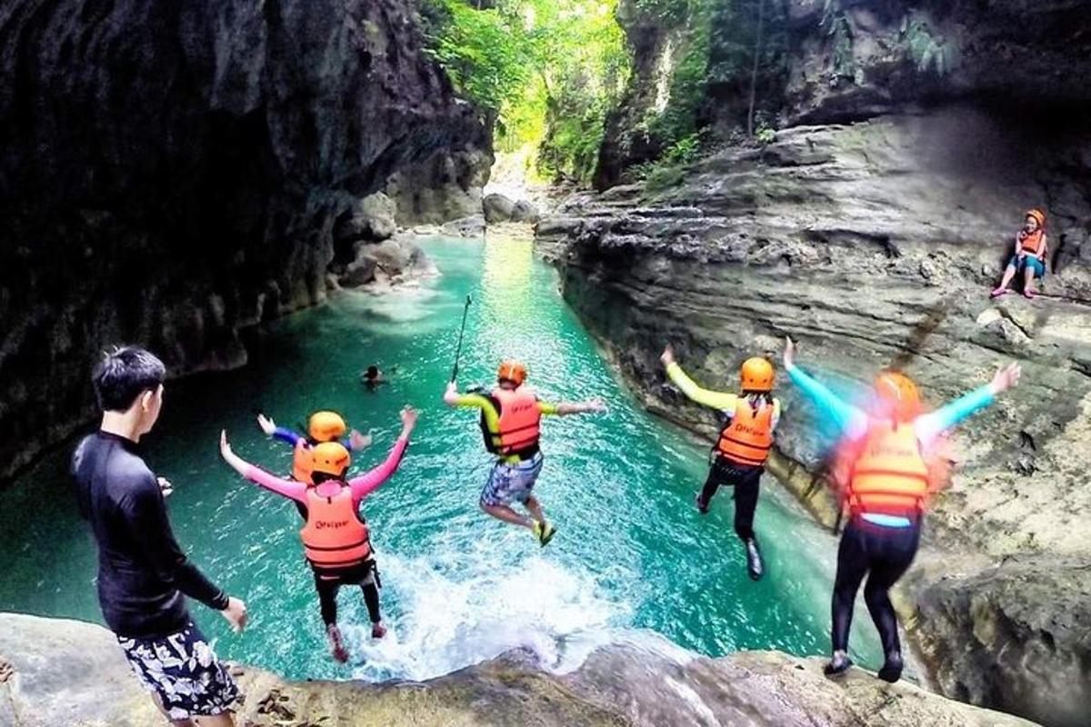a group of people jumping off a cliff into a river