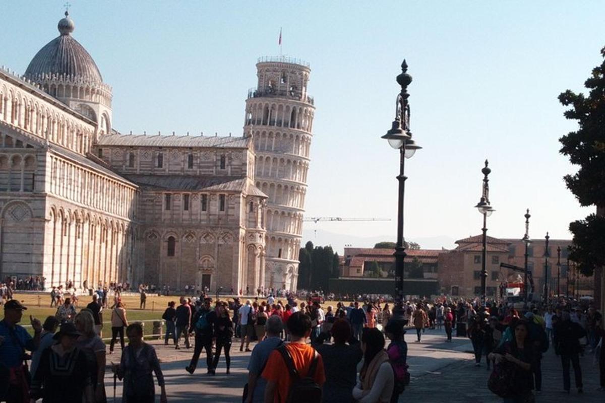 Un grupo de personas de pie frente a la torre inclinada