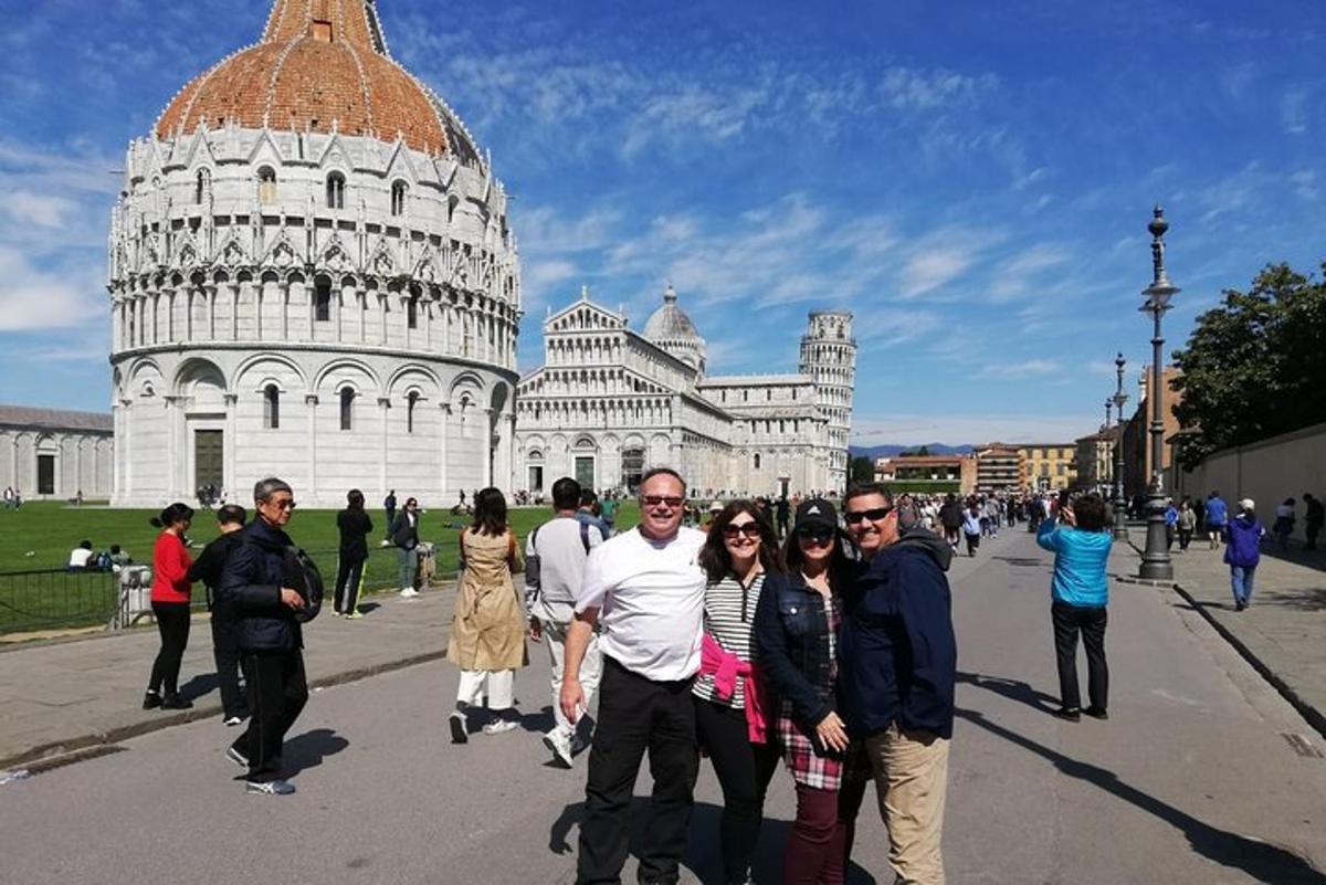 un gruppo di persone in piedi davanti alla torre pendente
