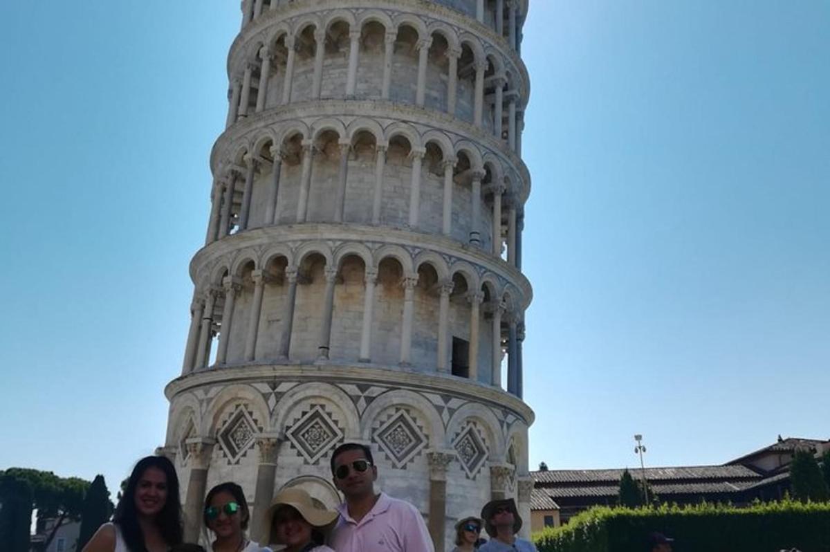 un gruppo di persone in piedi davanti alla torre pendente
