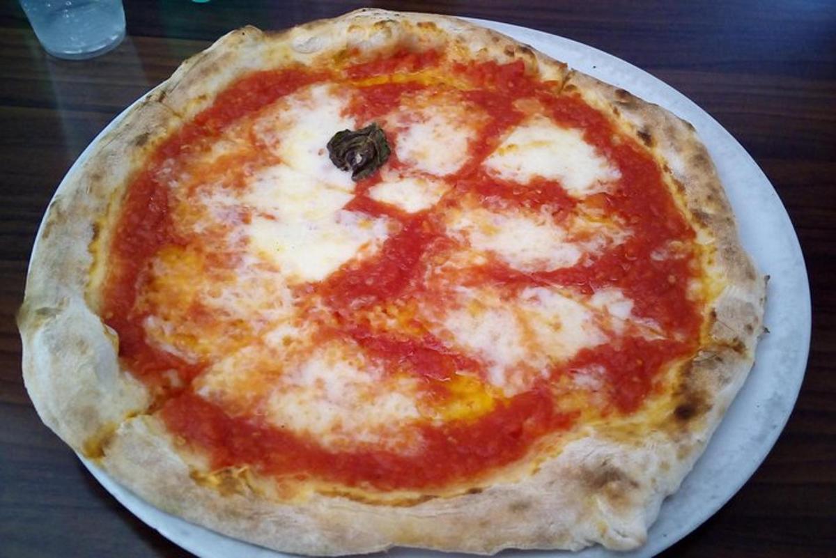 en ostepizza, der ligger på en tallerken på et bord