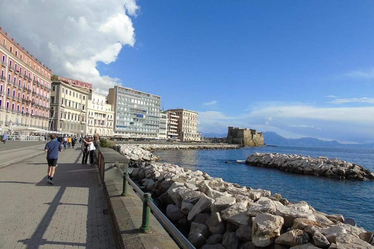 un gruppo di persone che camminano su un marciapiede vicino all'acqua
