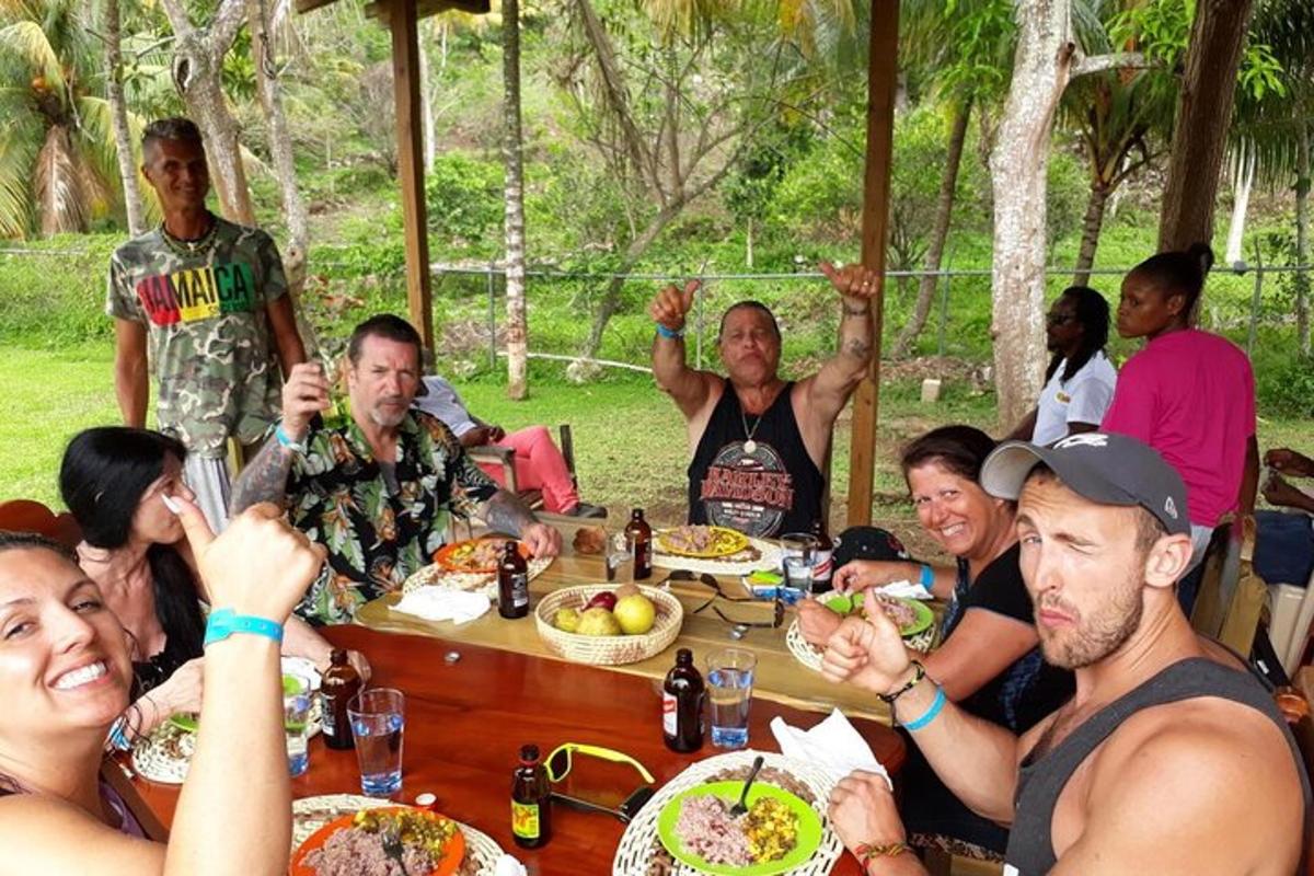 un gruppo di persone sedute attorno a un tavolo che mangiano cibo