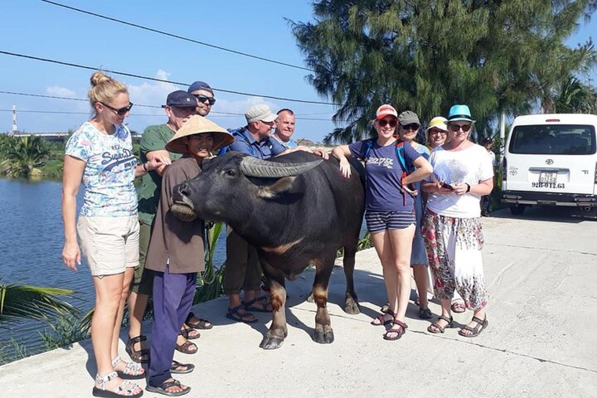 un gruppo di persone in piedi accanto a una mucca