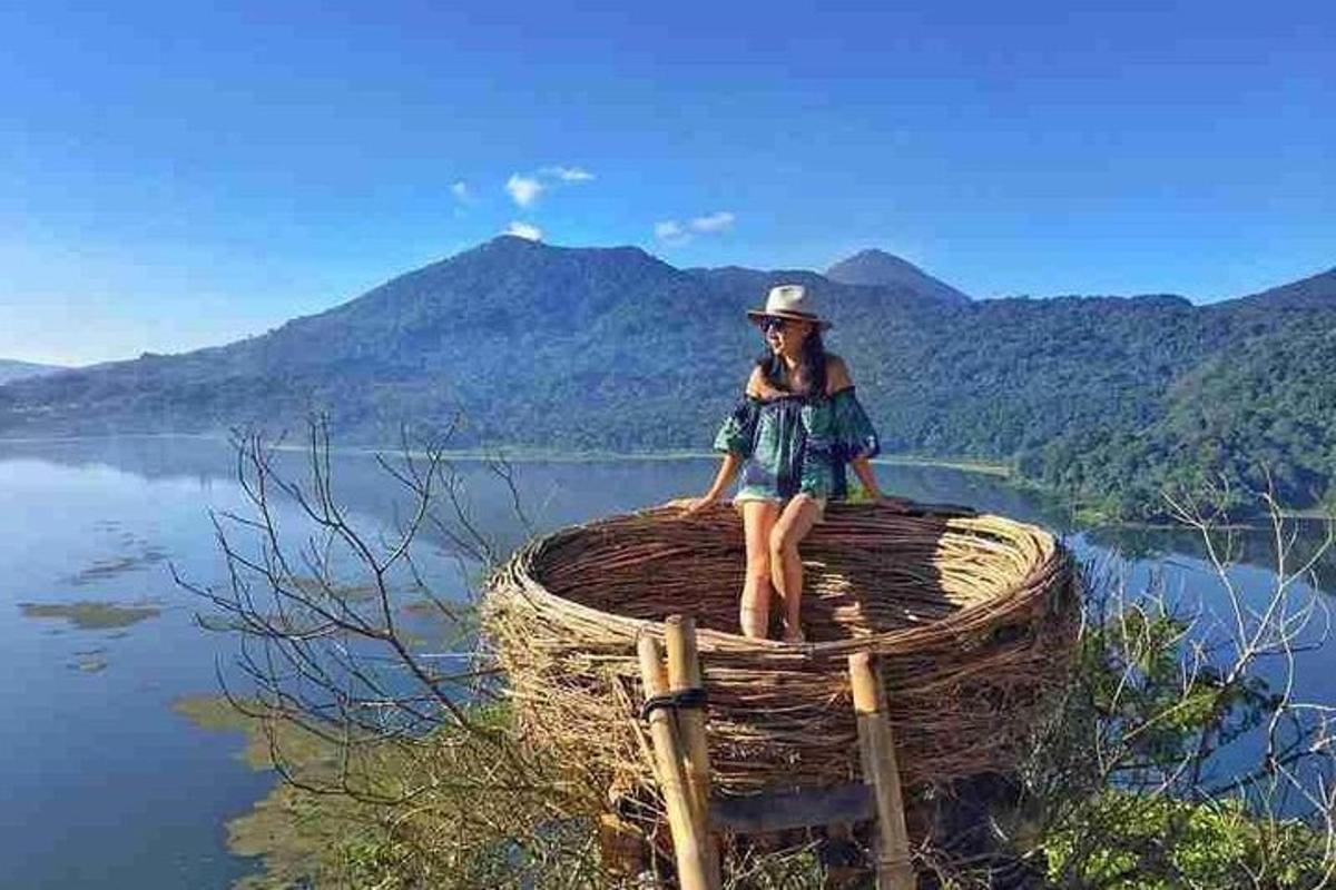 una dona asseguda a sobre d'una cistella sobre una massa d'aigua