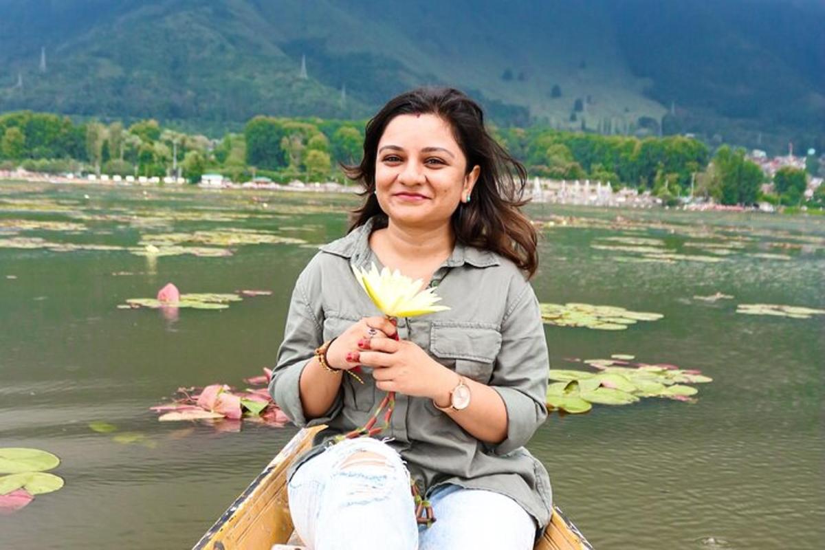 naine istub paadis ja hoiab käes lille