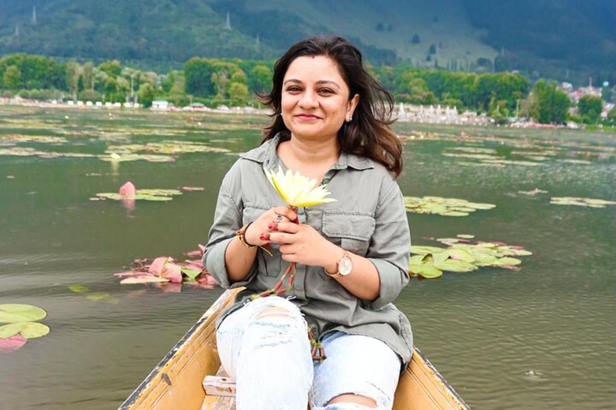 naine istub paadis ja hoiab käes lille