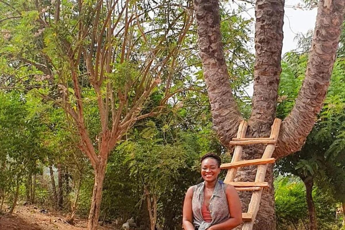a woman standing next to a tree with a ladder