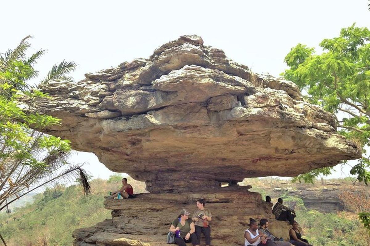 a group of people sitting on a rock formation