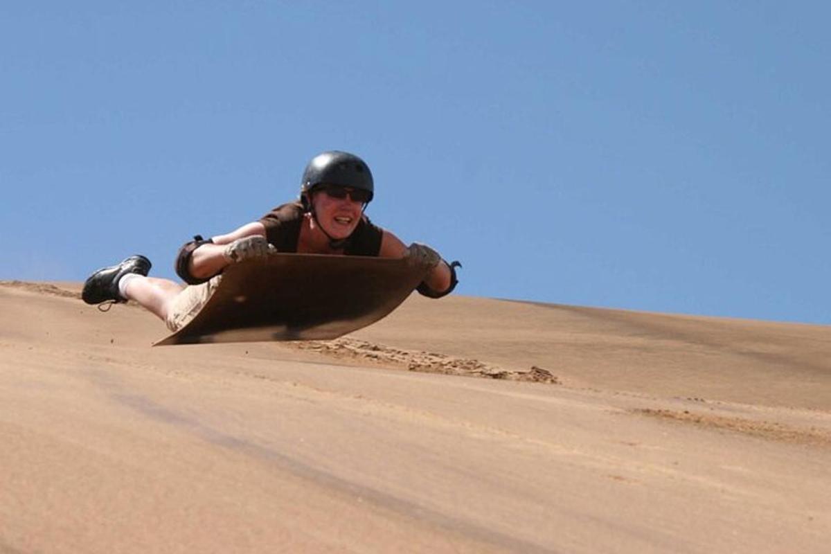a person laying on a surfboard in the desert