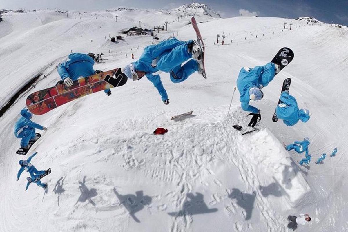 osoba předvádějící trik ve sněhu se snowboardem