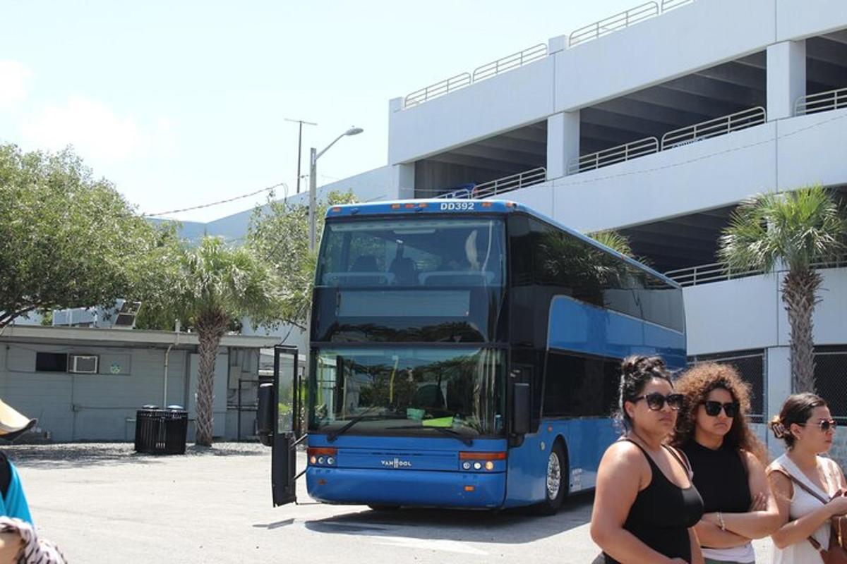 two women standing in front of a blue double decker bus