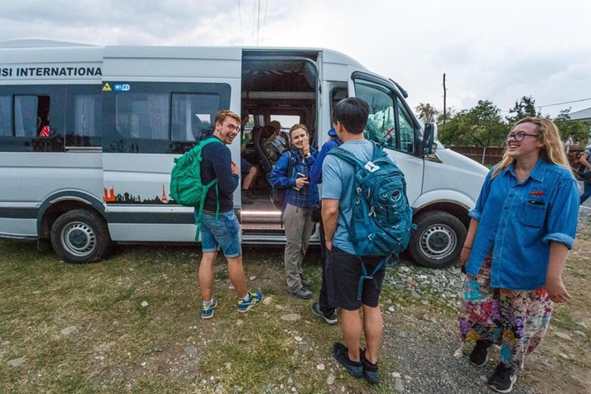 a group of people standing outside of a bus