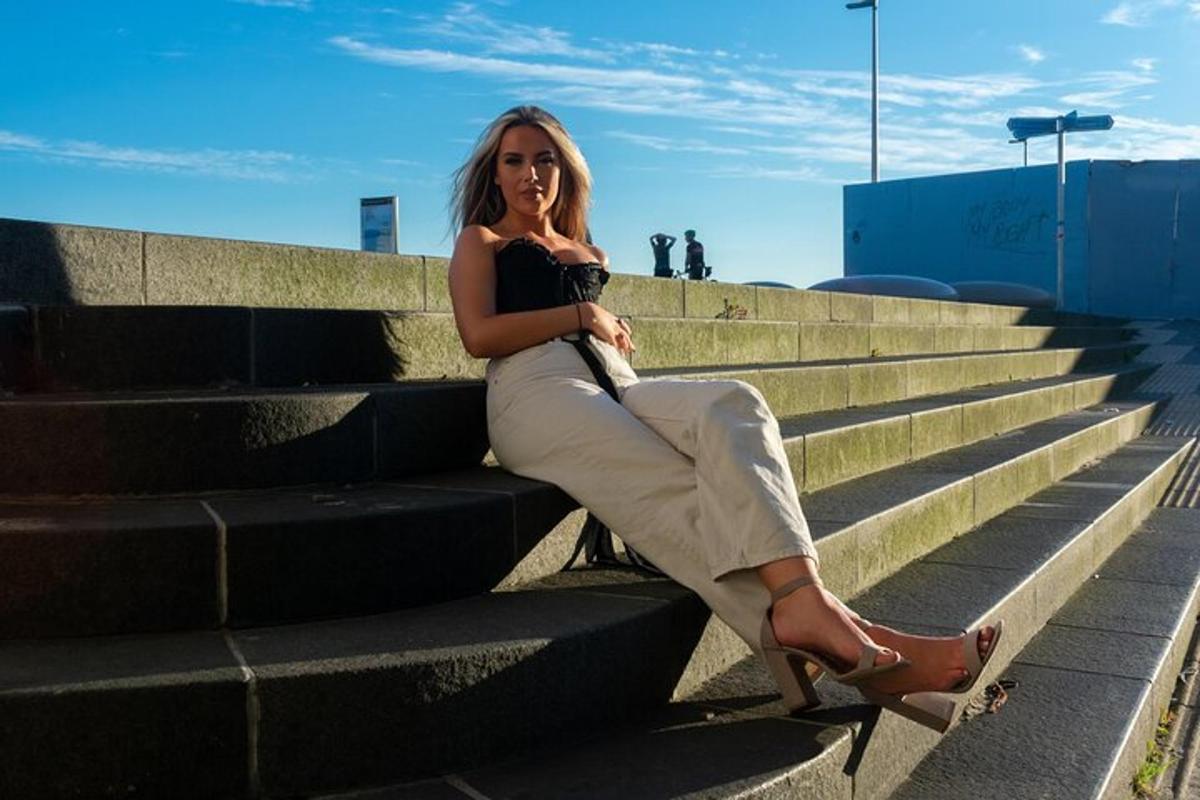 žena sedící na schodech v černém topu