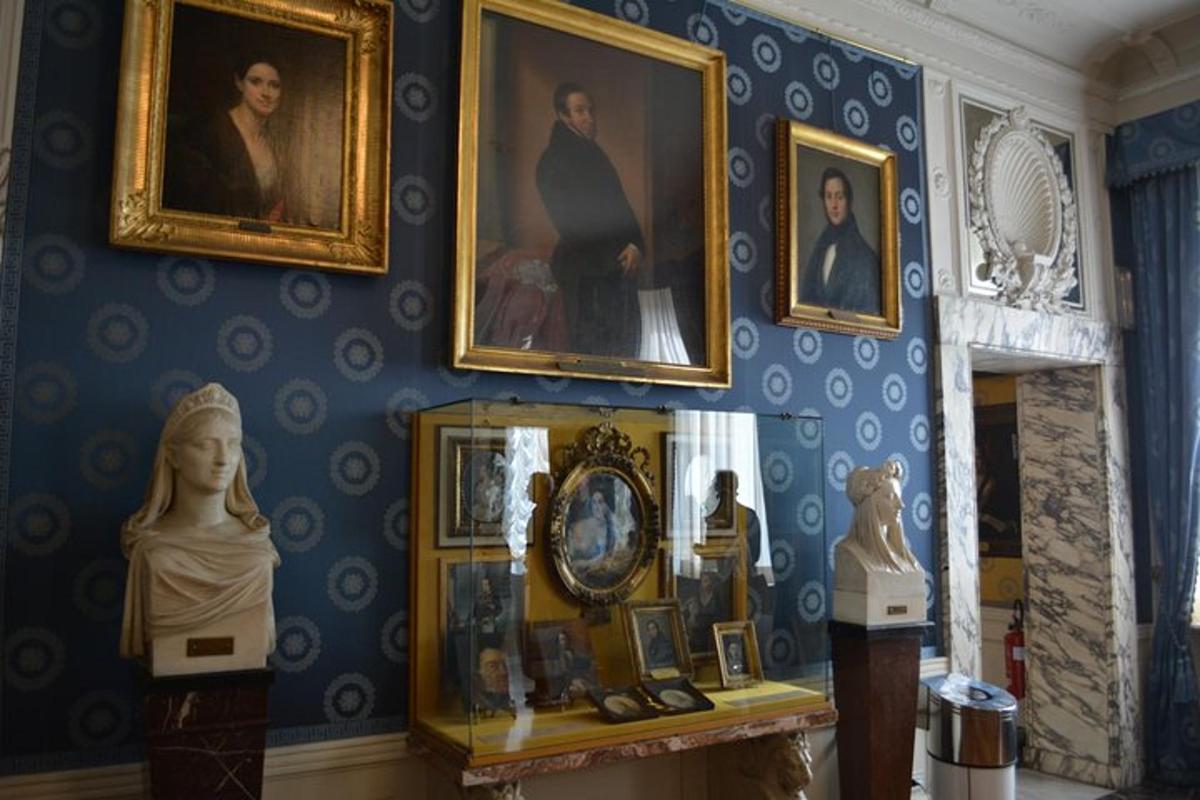 Una habitación con pinturas y cuadros en una pared.