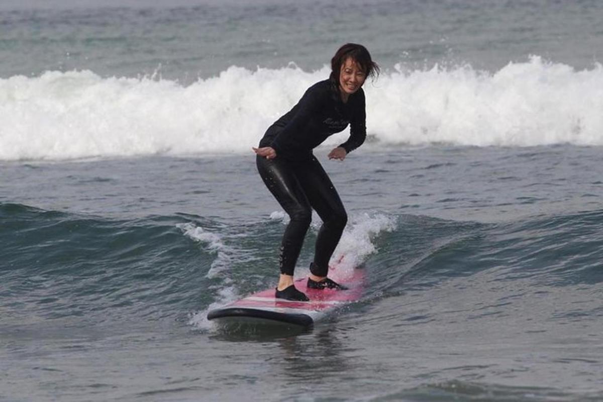 una donna che cavalca un'onda su una tavola da surf nell'oceano